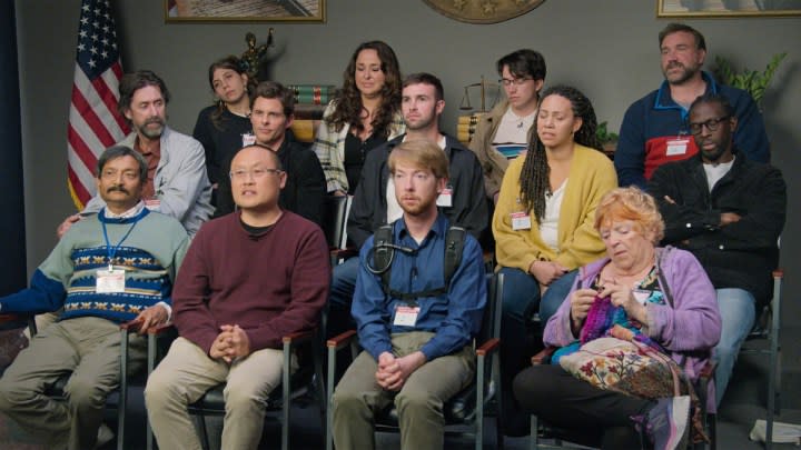 The cast of Jury Duty sitting together and looking intently.