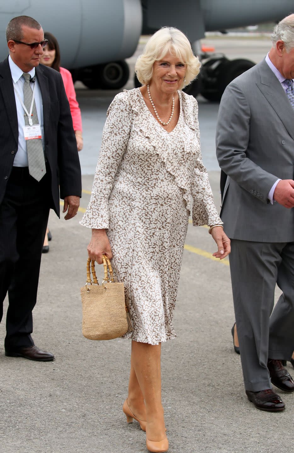 <p>For the royal couple's historic visit to Cuba, Camilla arrived wearing a ruffled brown and white printed dress. She complimented her look with a straw bag, nude heels, and a long-stranded pearl necklace. </p>