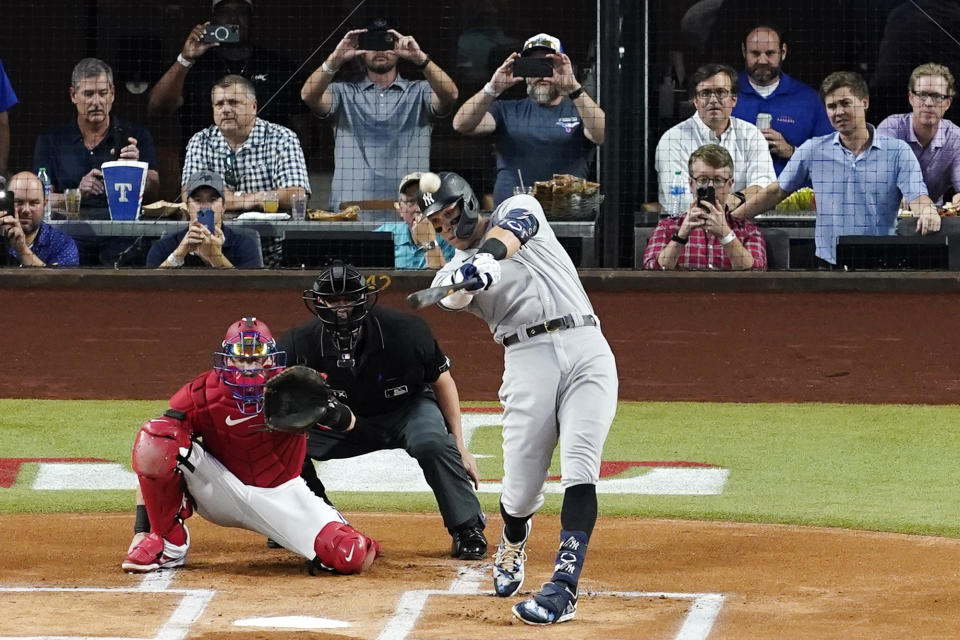 New York Yankees' Aaron Judge connects for a solo home run, his 62nd of the season, off as Texas Rangers catcher Sam Huff and umpire Randy Rosenberg look on in the first inning of the second baseball game of a doubleheader in Arlington, Texas, Tuesday, Oct. 4, 2022. With the home run, Judge set the AL record for home runs in a season, passing Roger Maris. (AP Photo/Tony Gutierrez)