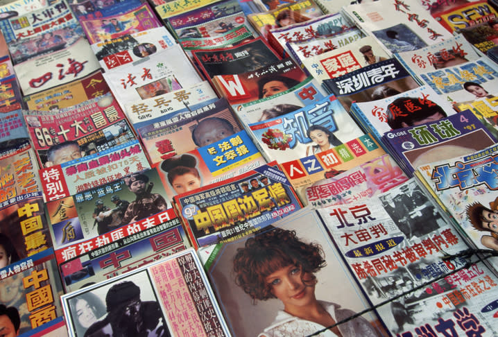 A variety of international entertainment magazines spread out, featuring celebrity news and pop culture