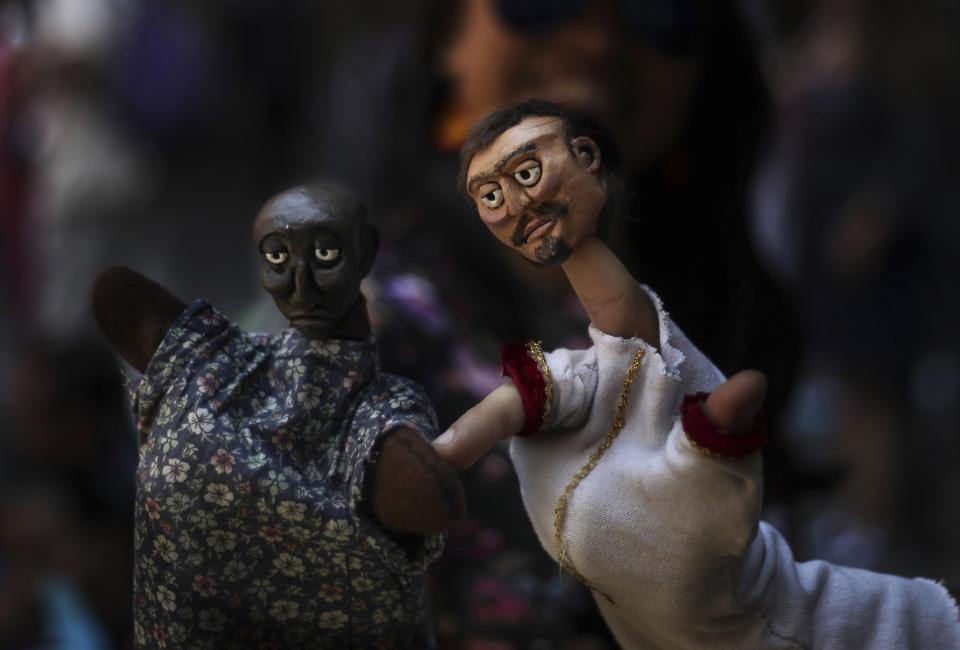 In this March 24, 2019 photo, a puppeteer presents his hand puppets during an event at the National Culture Museum in Mexico City. The event was held in honor of World Puppetry Day, observed earlier in the week on March 21. (AP Photo/Marco Ugarte)
