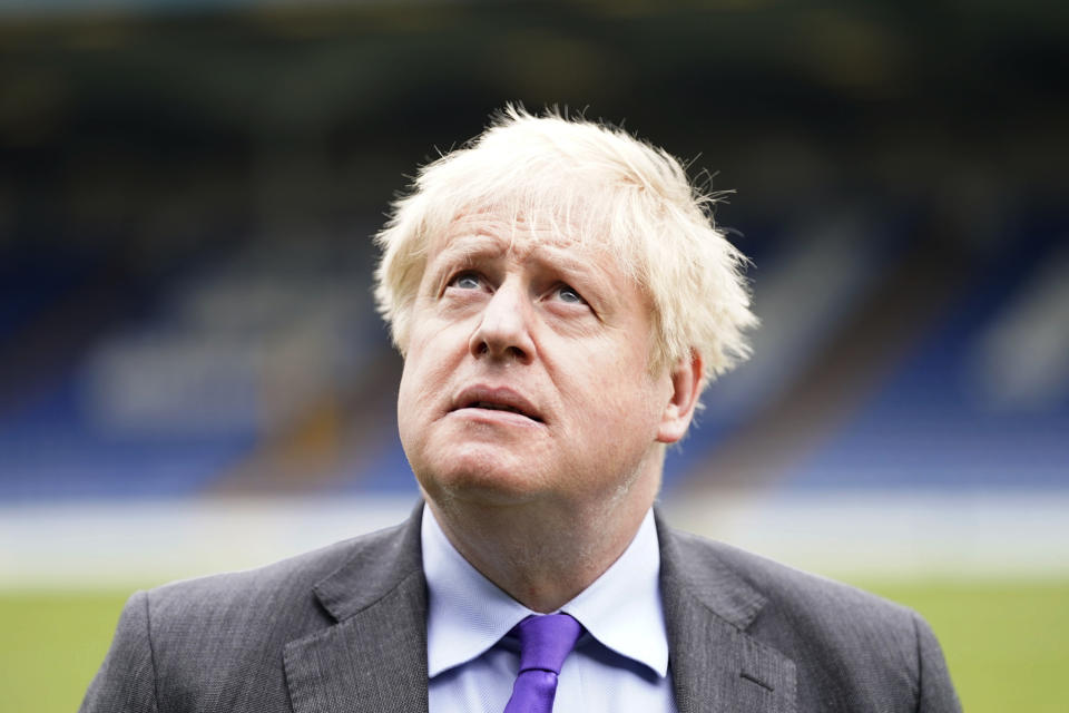 Britain's Prime Minister Boris Johnson looks on during a visit to Bury FC at their ground in Gigg Lane, Bury, Greater Manchester, England, Monday April 25, 2022. (Danny Lawson/Pool Photo via AP)