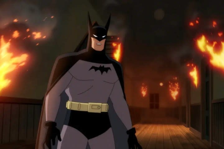 Batman stands in a burning building in Batman: Caped Crusader.