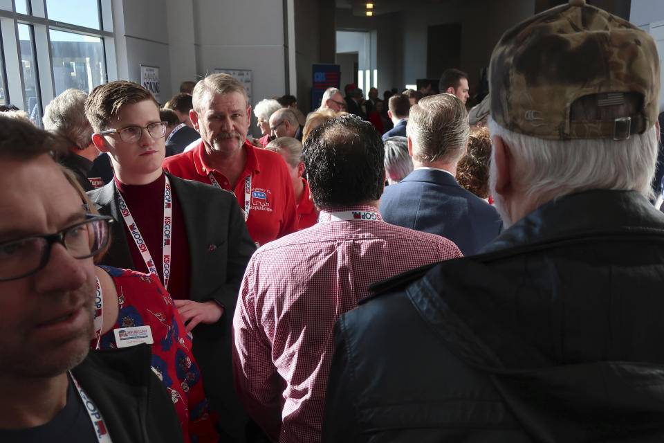 Dozens of Republican activists from Kansas crowd a hallway where vendors and candidates have set up tables for a statewide GOP convention, Saturday, Feb. 1, 2020, in Olathe, Kan. Republicans heard from GOP candidates for the U.S. Senate. (AP Photo/John Hanna)