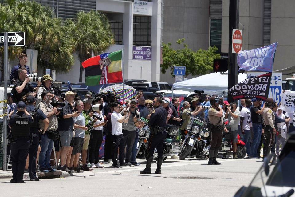 People watch as they motorcade carrying former President Donald Trump arrives at the Wilkie D. Ferguson Jr. U.S. Courthouse, Tuesday, June 13, 2023, in Miami. Trump is making a federal court appearance on dozens of felony charges accusing him of illegally hoarding classified documents and thwarting the Justice Department's efforts to get the records back. (AP Photo/Gerald Herbert)