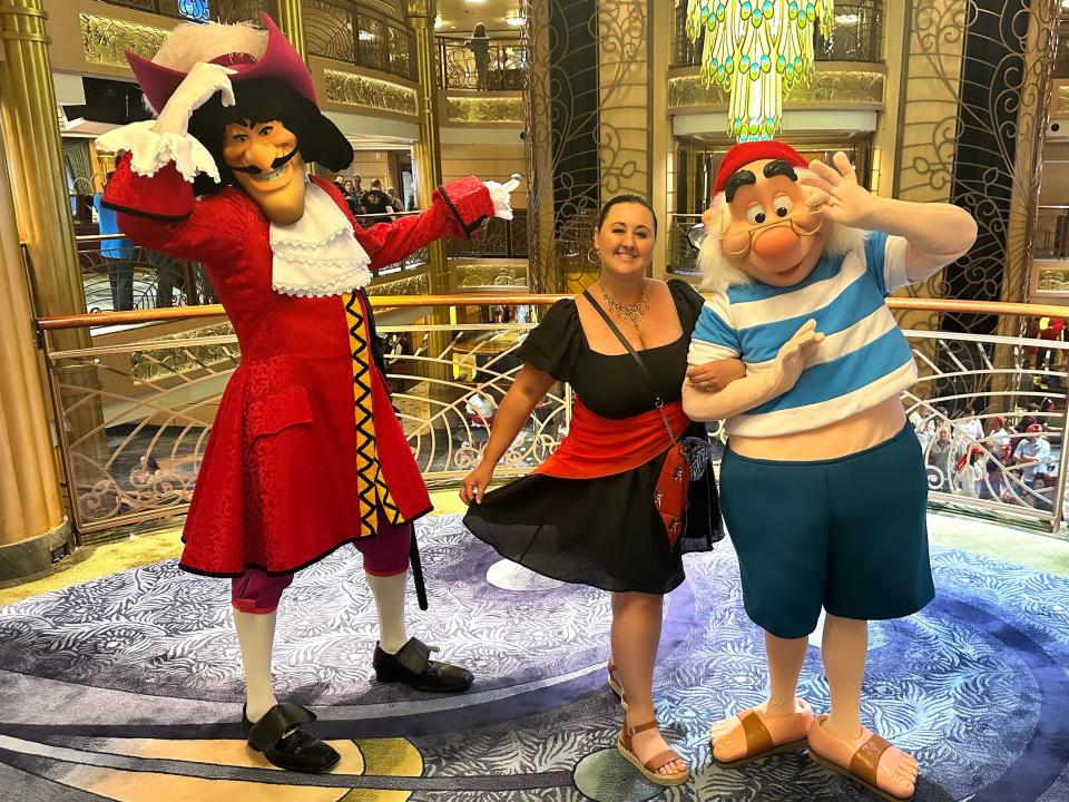 Carly dressed up as a pirate posing with Captain Hook and Smee.