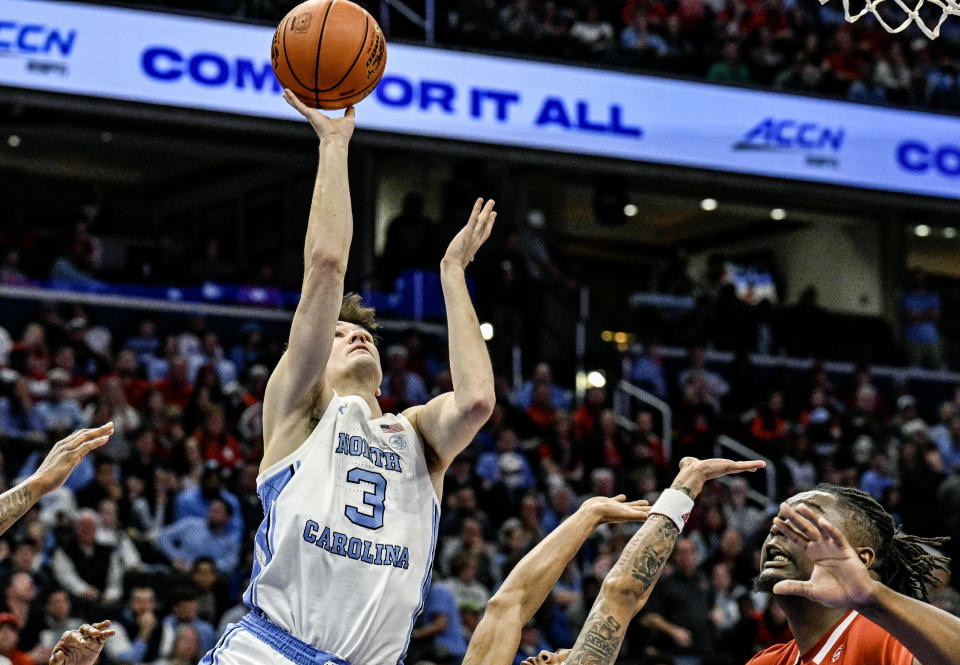 WASHINGTON, DC - MARCH 16: North Carolina Tar Heels guard Cormac Ryan (3) goes to the basket against North Carolina State Wolfpack forward DJ Burns Jr. (30) in the ACC Tournament Championship on March 16, 2024 at the Capital One Arena in Washington, D.C.  (Photo by Mark Goldman/Icon Sportswire via Getty Images)