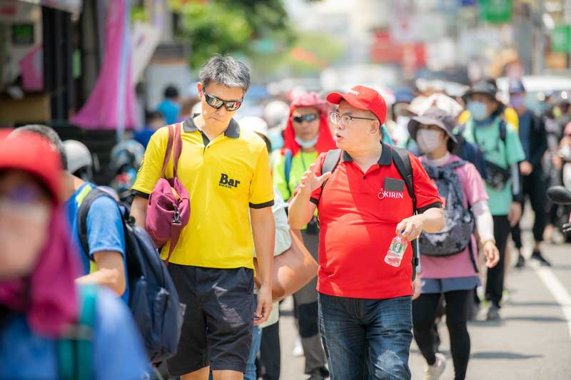 台灣麒麟董事長中川亮（圖左著黃衣）參加2023大甲媽祖遶境。（台灣麒麟提供）