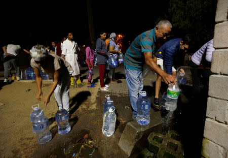 People queue to collect water from a spring in the Newlands suburb as fears over the city's water crisis grow in Cape Town, South Africa, January 25, 2018. REUTERS/Mike Hutchings