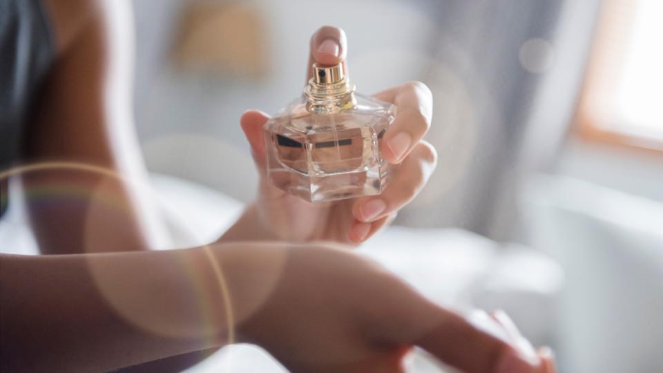 Woman spraying perfume on wrist to make it last longer