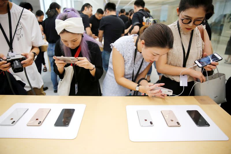 FILE PHOTO: People experience new Apple's iPhone XS and iPhone XS Max during a media tour at an Apple office in Shanghai