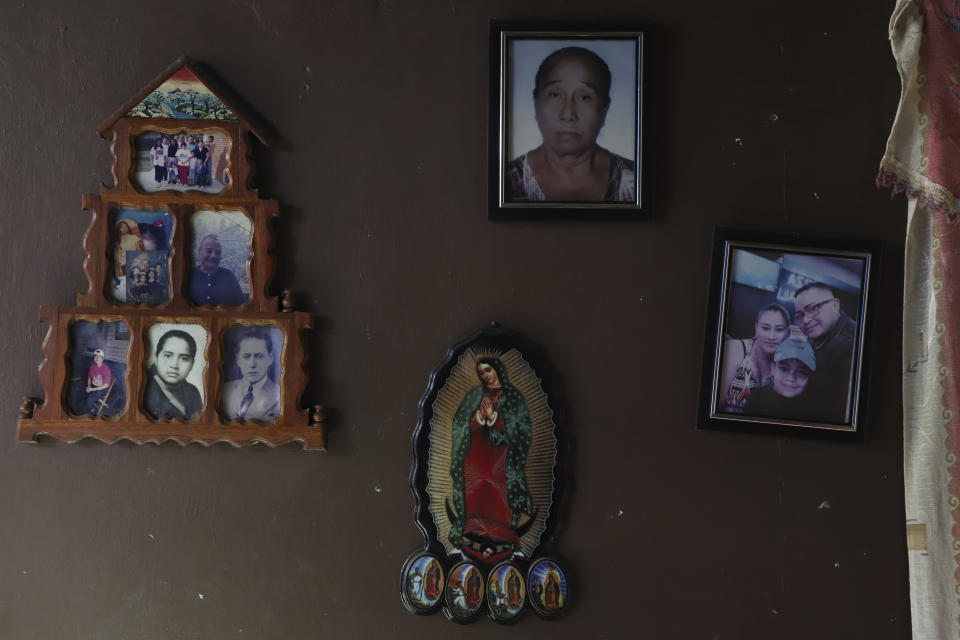 An Our Lady of Guadalupe wooden plaque and family photos adorn a wall in the home of Fabricio Chicas, a transgender man, in San Salvador, El Salvador, Sunday, April 30, 2023. When he was little, Chicas’ mother agreed to dress him in masculine clothes and called him “my boy.” Everything changed when he turned 9. She dressed him again in girl’s clothing and braided his hair. “I was so depressed I didn’t want to live,” he recalled. (AP Photo/Salvador Melendez)