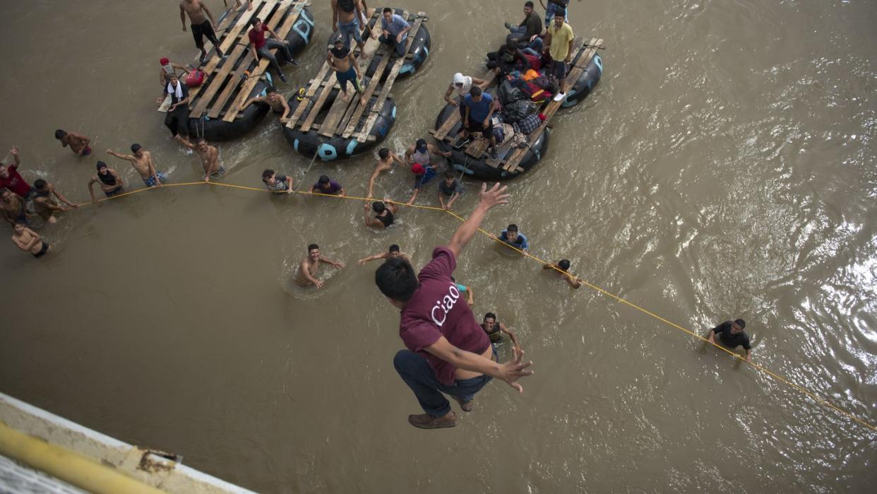 Ein honduranischer Migrant springt von einer Brücke in den Grenzfluss Suchiate. Foto: Oliver De Ros/AP