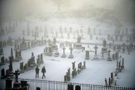 STIRLING, UNITED KINGDOM - DECEMBER 03: Two men walk through Stirling Castle graveyard on December 3, 2012 in Stirling, Scotland. Snow and sleet has hit many parts of Scotland with heavier falls expected over higher grounds. (Photo by Jeff J Mitchell/Getty Images)