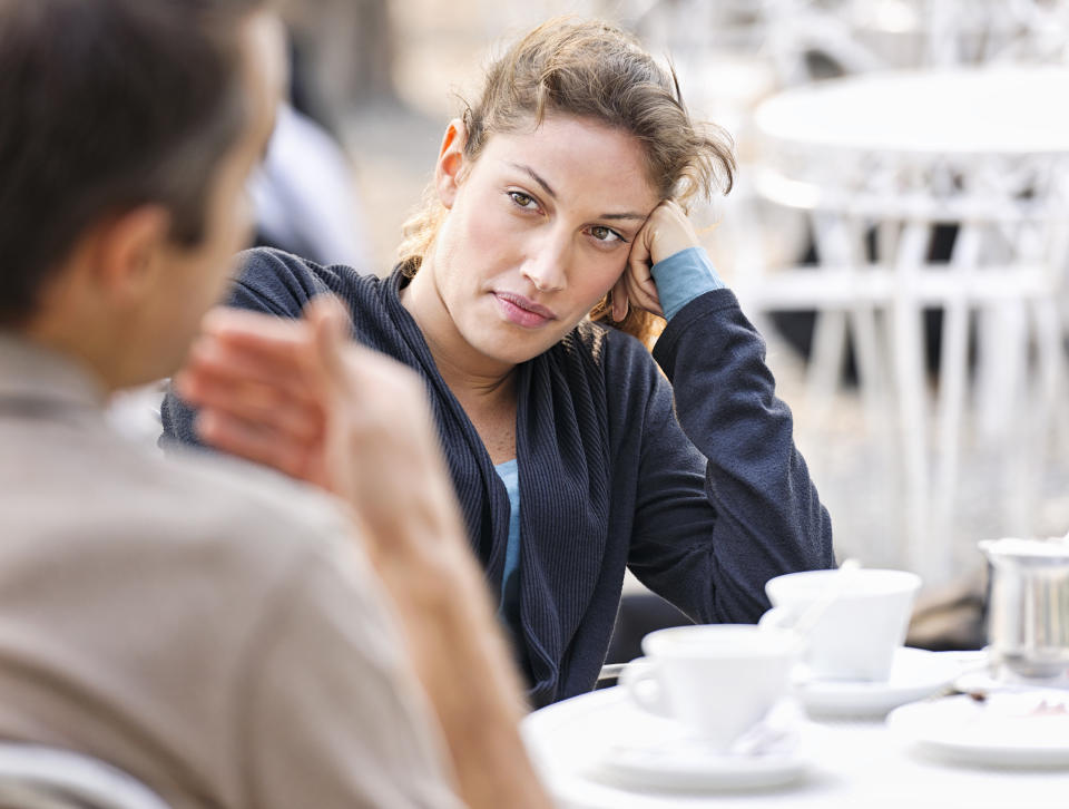 A woman listening to a man (defocussed) talking during a discussion