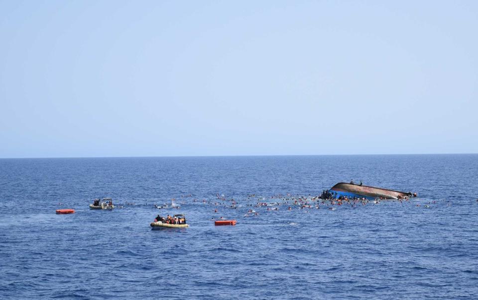 SICILIAN STRAIT, MEDITERRANEAN SEA - MAY 25: Migrants in a capsized boat are rescued by Bettica and Bergamini ships of Italian Navy at Sicilian Strait, between Libya and Italy, in Mediterranean sea on May 25, 2016. The Italian Navy saved around 500 migrants as they found dead bodies of seven migrants in the sea during the operations. (Photo by Italian Navy / Marina Militare/Anadolu Agency/Getty Images)