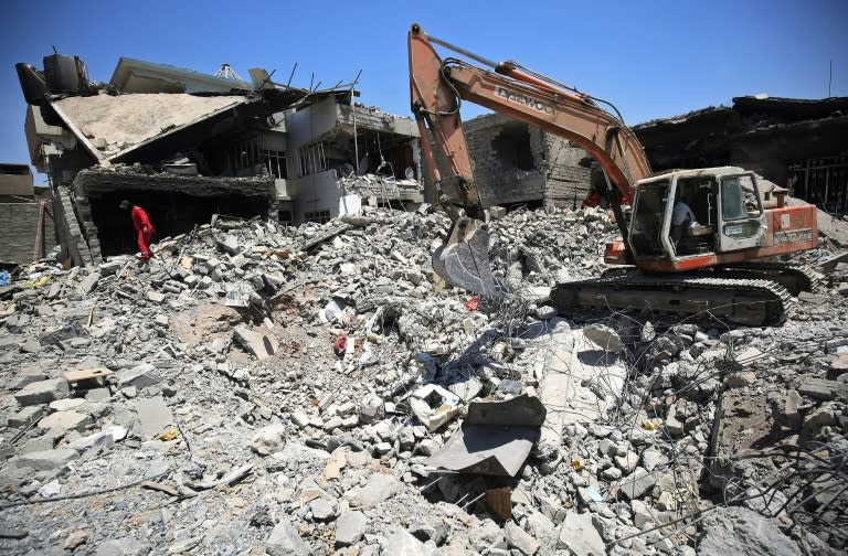 Iraqi civil defence search and rescue workers search for the bodies of victims under the rubble of buildings following bombardment in western Mosul's Zanjili district on June 27, 2017