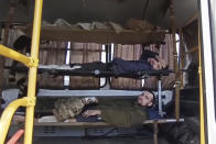 In this photo taken from video released by the Russian Defense Ministry Press Service on Tuesday, May 17, 2022, wounded Ukrainian servicemen lay in a bus as they are being evacuated as they are being evacuated from the besieged Azovstal steel plant in Mariupol, Ukraine. More than 260 fighters, some severely wounded, were pulled from a steel plant on Monday that is the last redoubt of Ukrainian fighters in the city and transported to two towns controlled by separatists, officials on both sides said. (Russian Defense Ministry Press Service via AP)