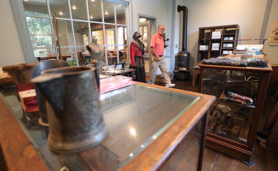 Tallmadge Historical Society President Chris Grimm walks through the general store display in the museum at Old Town Hall, which was built in 1859.