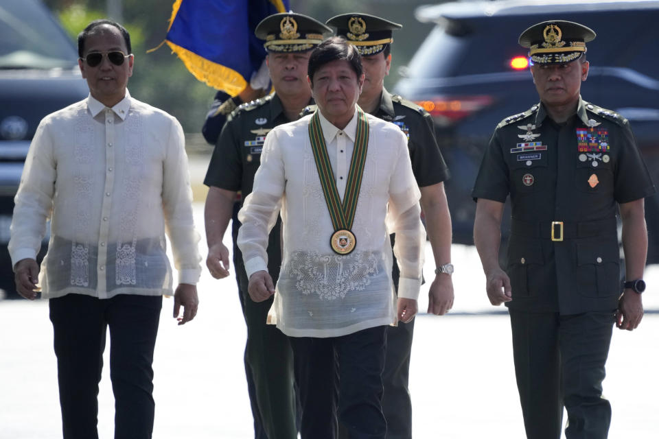 Philippine President Ferdinand Marcos Jr., center, walks beside Philippine Army Commanding General Lt. Gen. Romeo Brawner Jr., right, and Department of National Defense Office in Charge Carlito Galvez Jr., left, during rites at the 126th founding anniversary of the Philippine Army at Fort Bonifacio in Taguig, Philippines on Wednesday, March 22, 2023. (AP Photo/Aaron Favila)