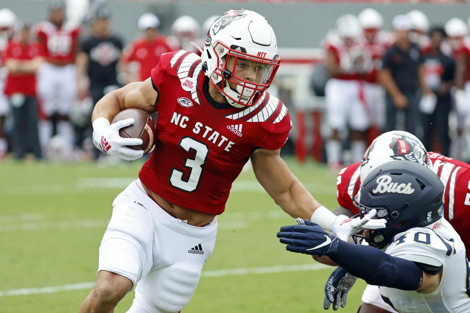 North Carolina State's Jordan Houston (3) stiff arms Charleston Southern's Garrett Sayegh (40) on his way to a long gain during the first half of an NCAA college football game in Raleigh, N.C., Saturday, Sept. 10, 2022. (AP Photo/Karl B DeBlaker)