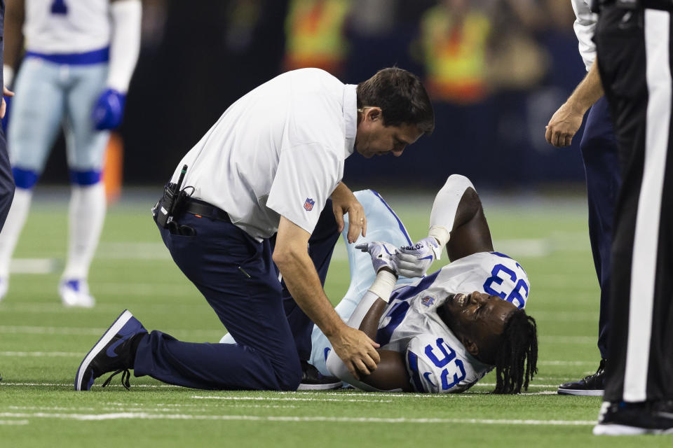 A trainer tends to Dallas Cowboys defensive end Tarell Basham (93) after suffering an injury during an NFL football game against the Tampa Bay Buccaneers, Sunday, Sept. 11, 2022, in Arlington, Texas. Hamstring pulls, ligament tears and ankle sprains can be as formidable an opponent for NFL teams as a high-scoring offense or stingy defense. (AP Photo/Brandon Wade)