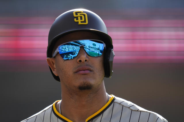 Dodger Stadium is reflected in the sunglasses of San Diego Padres' Manny Machado (13) as he returns to the dugout after flying out during the third inning of a baseball game against the Los Angeles Dodgers in Los Angeles, Saturday, May 13, 2023. (AP Photo/Ashley Landis)