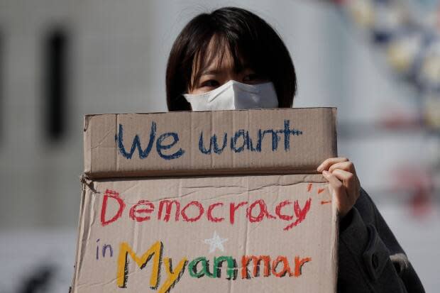 A member of a South Korean civic group holds a sign as she attends at a rally against Myanmar's military coup in Seoul, South Korea, Wednesday, March 3, 2021.