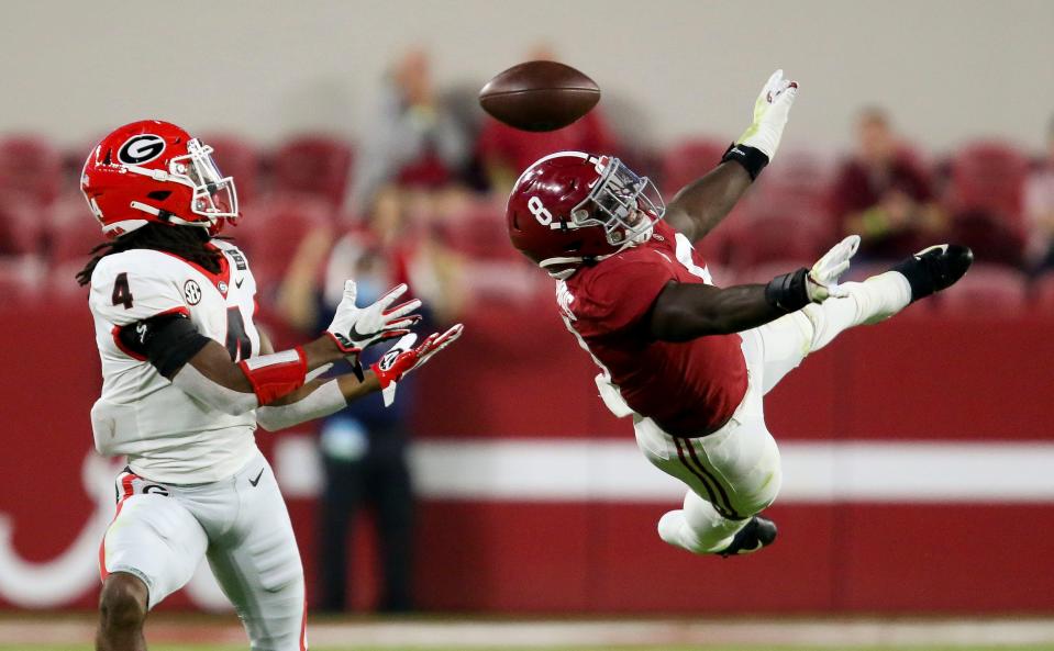 Oct 17, 2020; Tuscaloosa, Alabama, USA; Georgia running back James Cook (4) catches a pass which he ran in for a touchdown as Alabama linebacker Christian Harris (8) leaps but can't deflect the ball during the first quarter at Bryant-Denny Stadium. Gary Cosby Jr/The Tuscaloosa News via USA TODAY Sports