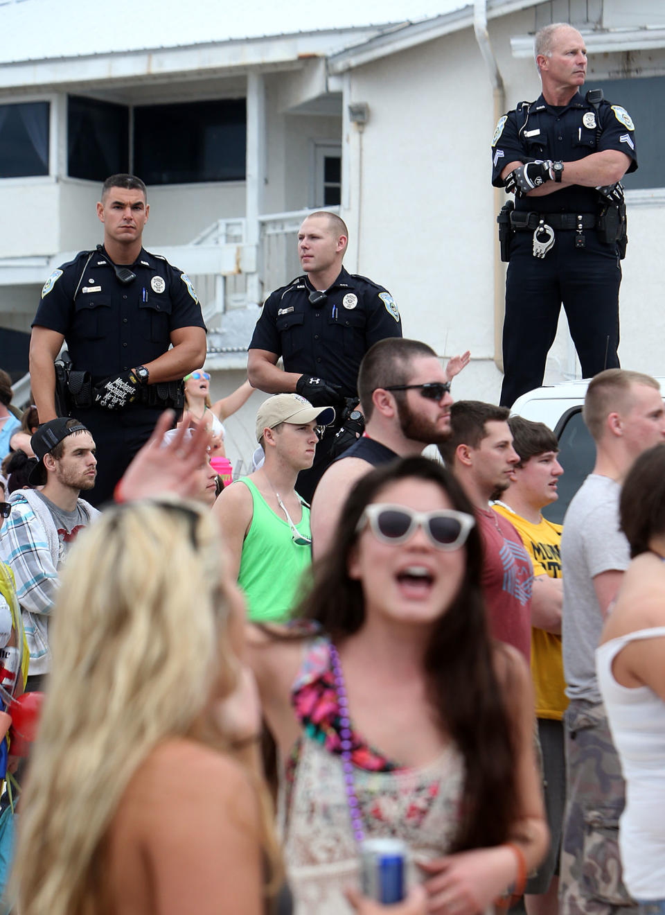 FILE - This March 11, 2014 file photo shows Panama City Beach Police Officers watching over a large crowd of spring breakers during a Luke Bryan concert in Panama City, Fla. (AP Photo/The News Herald/Panama City, Fla., Andrew Wardlow)