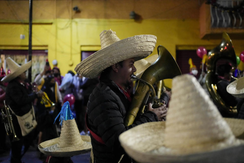 A music participate in the procession of "Ninopan" during a Christmas "posada," which means lodging or shelter, in the Xochimilco borough of Mexico City, Wednesday, Dec. 21, 2022. For the past 400 years, residents have held posadas between Dec. 16 and 24, when they take statues of baby Jesus in procession to church for Mass to commemorate Mary and Joseph's cold and difficult journey from Nazareth to Bethlehem in search of shelter. (AP Photo/Eduardo Verdugo)