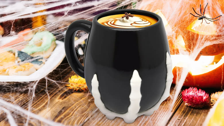 black mug with skeleton fingers