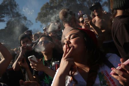 People smoke marijuana joints at 4:20 p.m. as thousands of marijuana advocates gather in Golden Gate Park in San Francisco, California April 20, 2012. REUTERS/Robert Galbraith/File photo