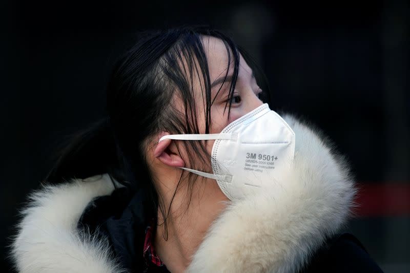 A woman wearing a mask is seen upon her arrival at Shanghai railway station in Shanghai