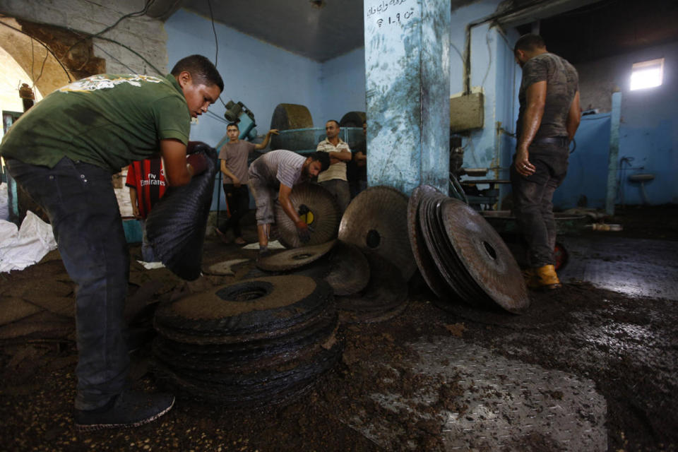 <p>Palestinian workers empty crushed olives between metal plates at a traditional stone press in the Palestinian village of Beta, west of Nablus, Oct. 14, 2016. Farmers are harvesting their olives this year from Oct. 1-Nov. 10. According to U.N. figures, some 80,000 Palestinian families earn their income from growing olives. (Photo: ALAA BADARNEH/EPA)</p>