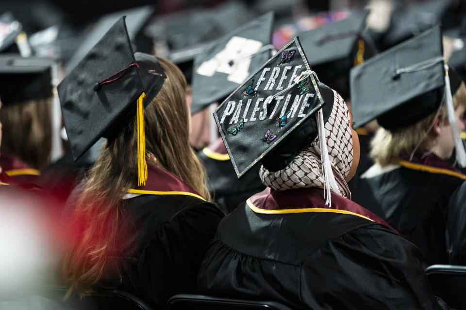 A student sits with her cap decorated to read "Free Palestine" while attending the University of Minnesota's College of Liberal Arts graduation ceremony, Sunday, May 12, 2024, in Minneapolis, Minn. (Angelina Katsanis /Star Tribune via AP)