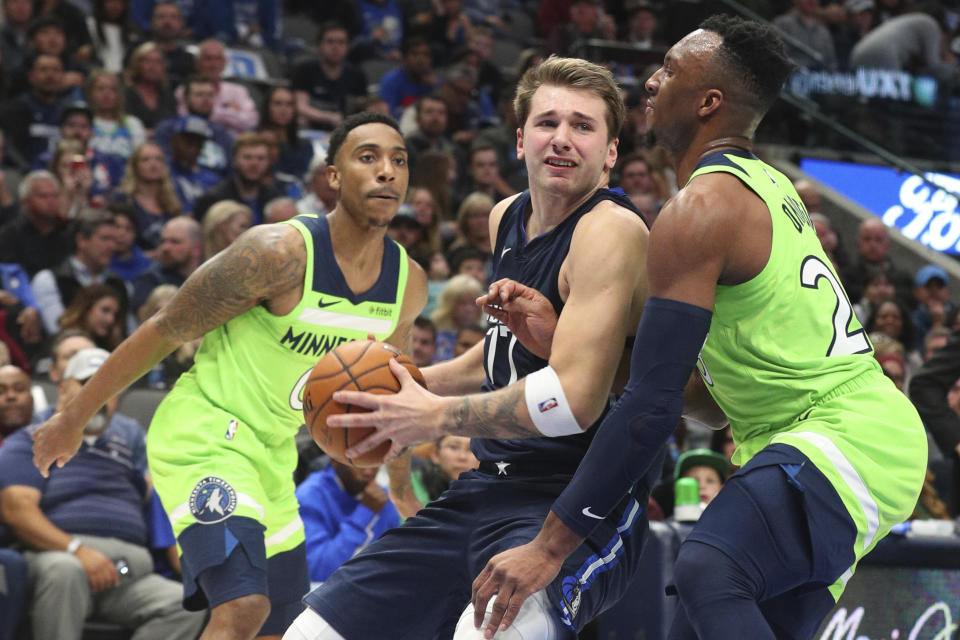 Dallas Mavericks forward Luka Doncic (77) tries to get past Minnesota Timberwolves guard Josh Okogie (20) for a shot in the second quarter of an NBA basketball game Wednesday, Dec. 4, 2019, in Dallas. (AP Photo/Richard W. Rodriguez)