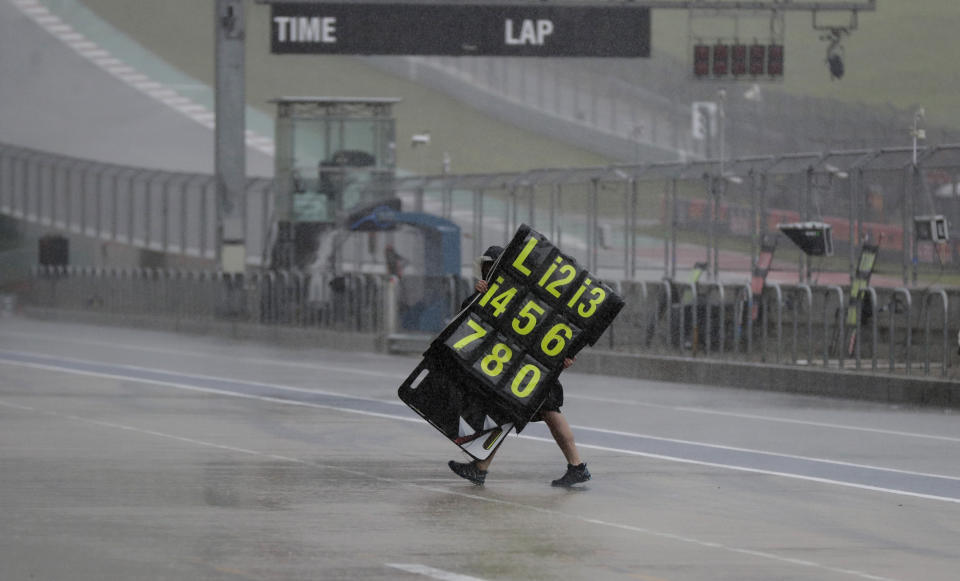 A crew member moves signage during a weather delay for practices and qualifying for the Grand Prix of the Americas motorcycle race at the Circuit Of The Americas, Saturday, April 13, 2019, in Austin, Texas. (AP Photo/Eric Gay)