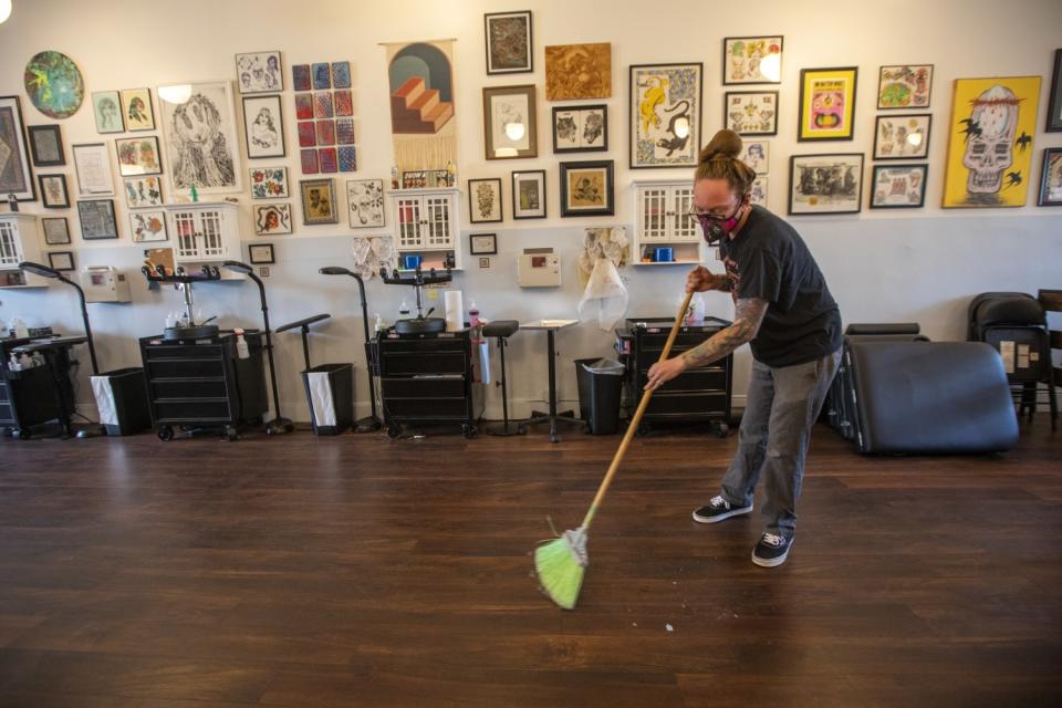 A man wears a mask as he sweeps.