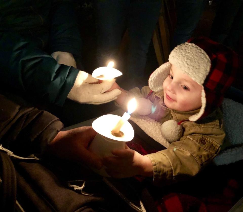 A young visitor to Roscoe Village experiences an old-fashioned candle light celebration.