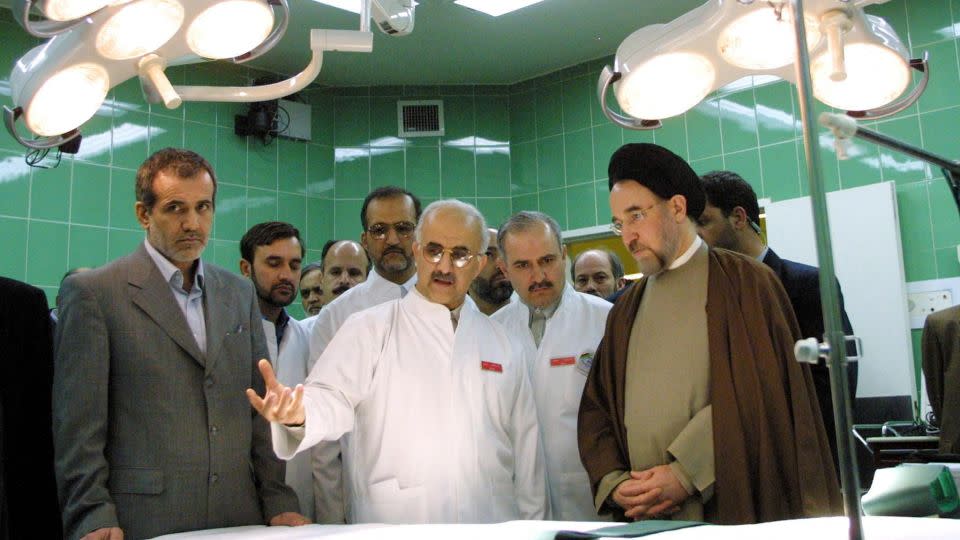 In this 2002 file photo, then-Health Minister Masoud Pezeshkian, left, and then-Iranian President Mohammad Khatami, right, listen to Abbas-Ali Karimi, center, head of Tehran's Cardiology Center, as they visit an operating room during the center's inauguration. - Behrouz Mehri/AFP/Getty Images/File