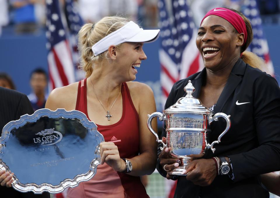 Wozniacki of Denmark holds her runner up trophy and shares a laugh with Williams of the U.S. after Williams won their women's singles finals match at the 2014 U.S. Open tennis tournament in New York