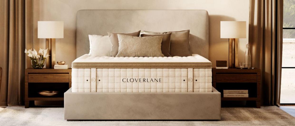  The Cloverlane Hybrid mattress placed upon a beige bed foundation within a stylish neutral  bedroom . 