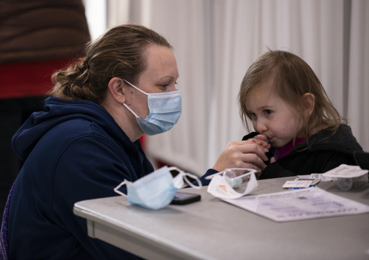 Amber Wischer helps her daughter Brecklin with a self-administered spit test at a COVID-19 testing facility in Stillwater, Minn. (Stephen Maturen/Getty Images)