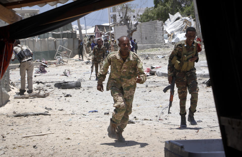 Somali government soldiers run to take positions during ongoing fighting with gunmen after a suicide car bomb attack on a government building in the capital Mogadishu, Somalia Saturday, March 23, 2019. Al-Shabab gunmen stormed into the government building following a suicide car bombing at the gates on Saturday, a police officer said, in the latest attack by Islamic extremist fighters in the Horn of Africa nation. (AP Photo/Farah Abdi Warsameh)