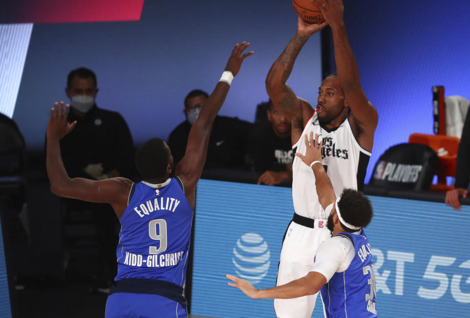 Los Angeles Clippers forward Kawhi Leonard (2) shoots against Dallas Mavericks guard Seth Curry (30) and forward Michael Kidd-Gilchrist (9) during the second half of Game 5 of an NBA basketball first-round playoff series, Tuesday, Aug. 25, 2020, in Lake Buena Vista, Fla. (Kim Klement/Pool Photo via AP)