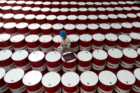 FILE PHOTO: A worker prepares to label barrels of lubricant oil at the state oil company Pertamina's lubricant production facility in Cilacap, Central Java, Indonesia November 6, 2017 in this photo taken by Antara Foto. Antara Foto/Rosa Panggabean/File Photo via REUTERS