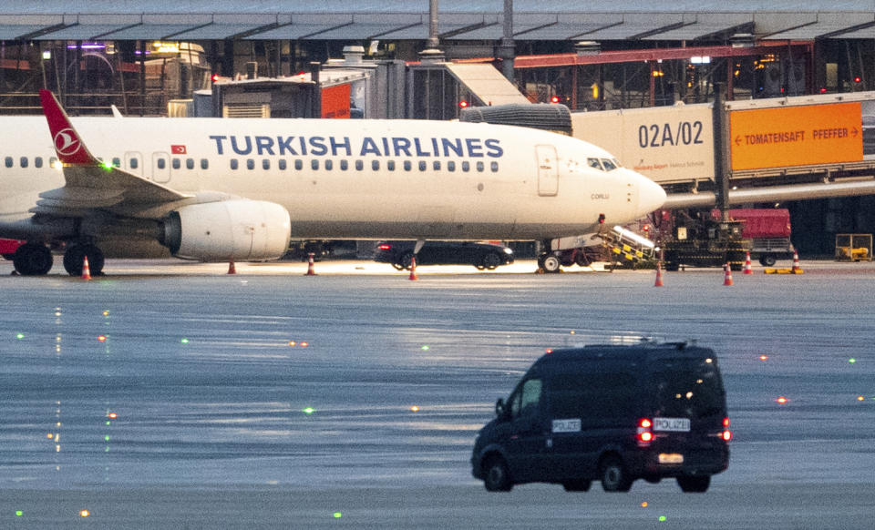 05 November 2023, Hamburg: A police vehicle is parked in front of an airplane at the airport, where a car with a hostage-taker is parked, in Hamburg, Germany, Sunday, Nov. 5, 2023. An armed man is holding his four-year-old daughter at the airport. According to the police, the background to the attack is a custody dispute.(Daniel Bockwoldt/dpa via AP)