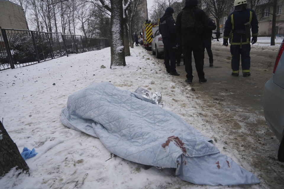 A body covered by blanket lies on the ground after Russian rocket attack in Kharkiv, Ukraine, Tuesday, Jan. 23, 2024. (AP Photo/Andrii Marienko)