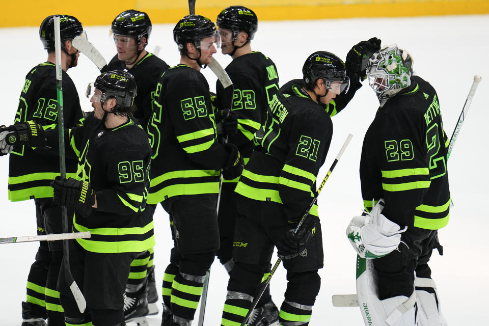 Dallas Stars goaltender Jake Oettinger (29), left wing Jason Robertson (21) and teammates react after defeating the Tampa Bay Lightning 8-1 during an NHL hockey game, Saturday, Dec. 2, 2023, in Dallas. (AP Photo/Julio Cortez)